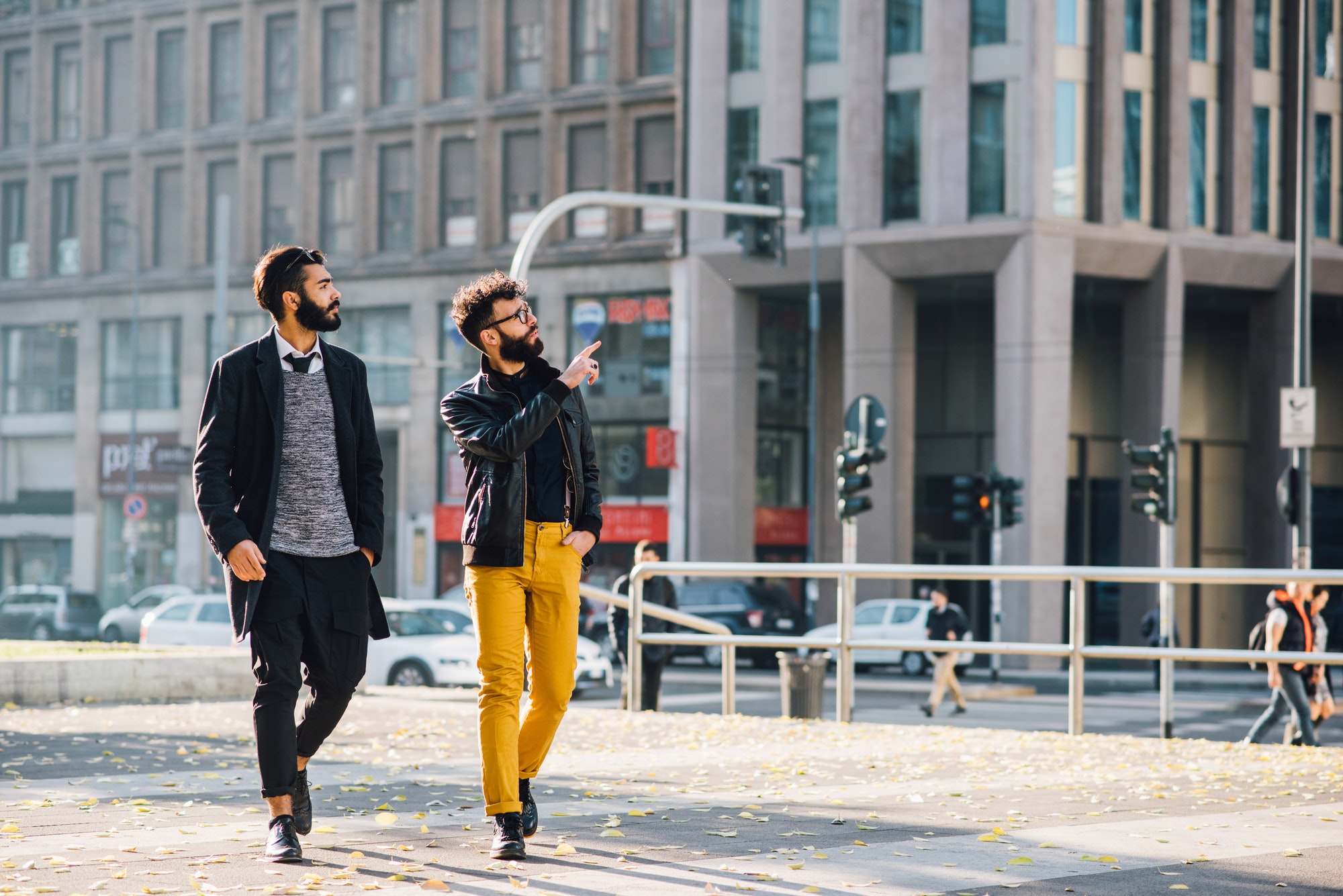 Two young bearded business man outdoor in the city walking